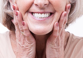 a woman holding her cheeks and smiling