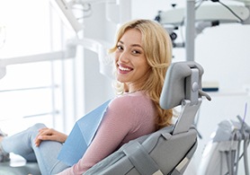 a smiling woman sitting in a dental chair