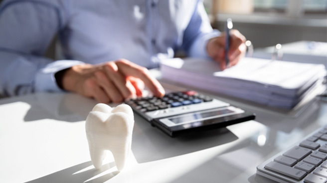 a man using a calculator and writing in a binder