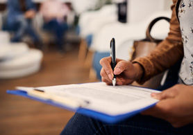 a woman in a waiting room filling out forms