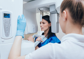 a woman receiving a cone beam CT scan at a dental office