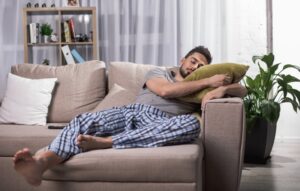 a man taking a nap on a couch